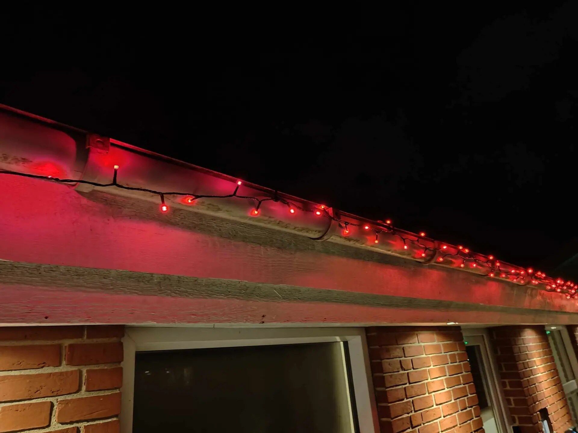 julelys i tagrenden i rød